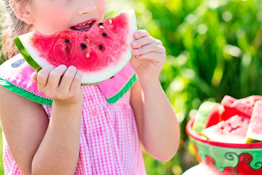 niña comiendo sandía refrescante del minifrigobar